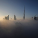 The sun rises over the city skyline with the Burj Khalifa, the world’s tallest building at the backdrop, seen from a balcony on the 42nd floor of a hotel on a foggy day in Dubai, United Arab Emirates.